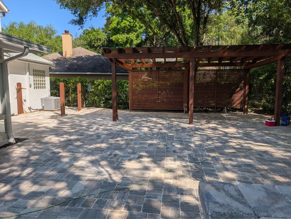 Gran patio de pavers con pérgola de madera construido por Marblu