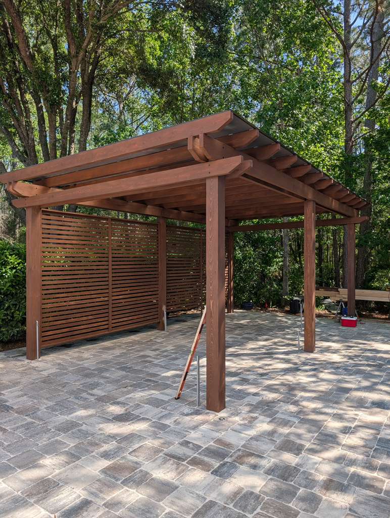 Pérgola de madera con panel de privacidad sobre un patio de travertino en Jacksonville